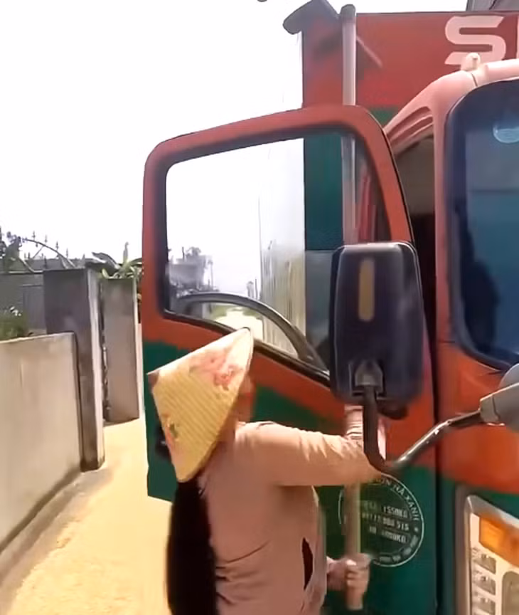 Người phụ nữ cầm cào đòi tấn công tài xế xe tải - Ảnh: Cắt từ clip