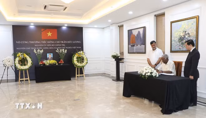 Tổng Bí Thư Đảng Cộng sản Ấn Độ Doraisamy Raja viết sổ tang. (Ảnh: Ngọc Thúy/TTXVN)