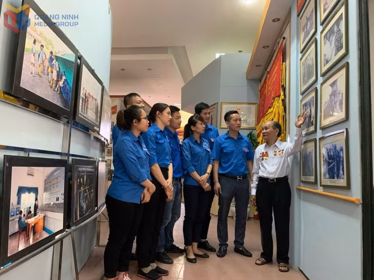 Đoàn viên thanh niên Công ty Tuyển than Cửa Ông trò chuyện, ôn lại truyền thống lịch sử với ông Vũ Đình Ba, nguyên là cán bộ đơn vị. Ảnh: Vũ Hằng (CTV)