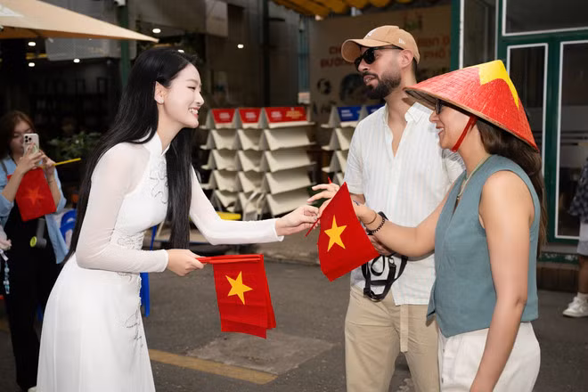 Du khách quốc tế được tặng cờ Tổ quốc tại Đường sách Thành phố Hồ Chí Minh. (Ảnh: CTV/Vietnam+)