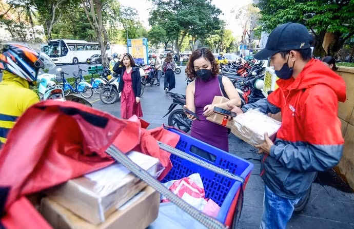 Người dân tại TP.HCM nhận hàng mua qua sàn thương mại điện tử - Ảnh: QUANG ĐỊNH