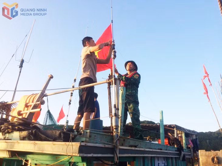 Thượng úy Nguyễn Bá Quân giúp ngư dân treo cờ Tổ quốc.