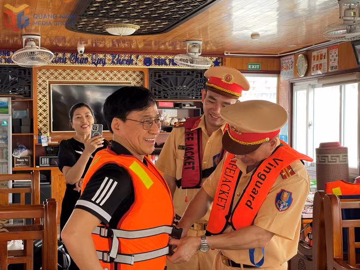 Cảnh sát đường thủy (Công an tỉnh) tuyên truyền, hướng dẫn ông Kim Kwang Hyok và gia đình đến từ Hàn Quốc mặc áo phao khi tham quan Vịnh Hạ Long.