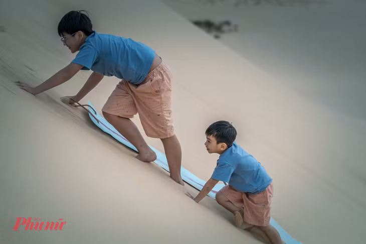 Trượt cát bằng ván mềm là trò chơi được nhiều du khách trẻ em yêu thích tại Bàu Cát