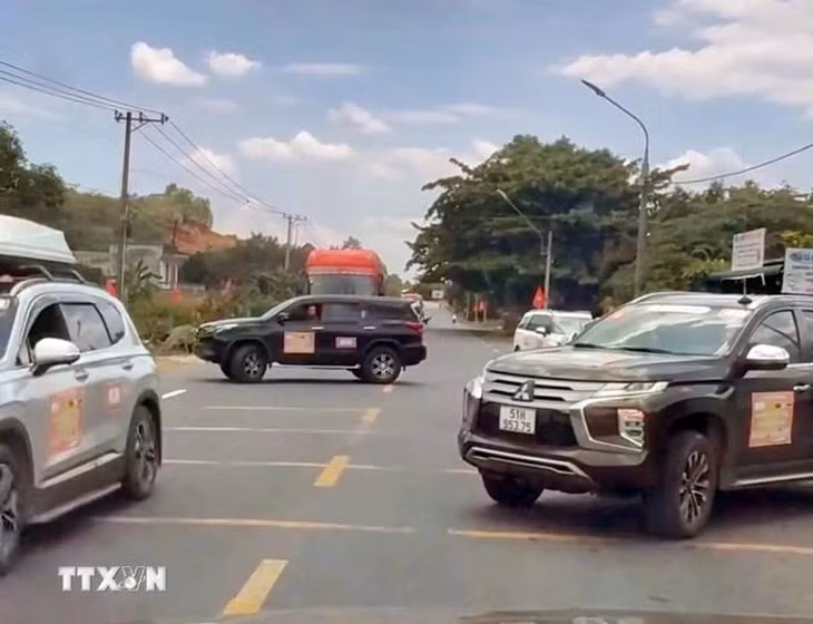 2 chiếc xe ngang nhiên đậu so le trên cả 2 chiều, chặn đường để đoàn xe doanh nhân băng qua Quốc lộ 20. (Ảnh: TTXVN phát)