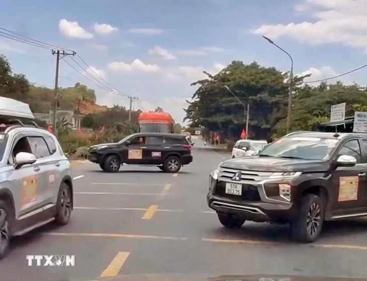 2 chiếc xe ngang nhiên đậu so le trên cả 2 chiều, chặn đường để đoàn xe doanh nhân băng qua Quốc lộ 20. (Ảnh: TTXVN phát)