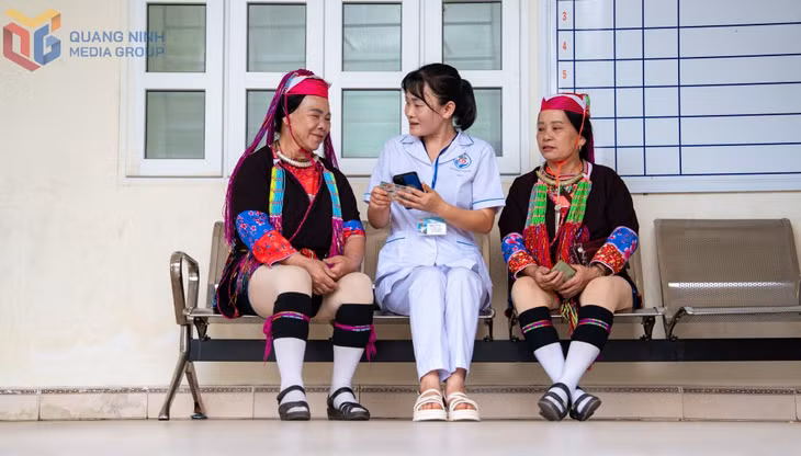 Chị Kiều Thị Thủy hướng dẫn người dân cài đặt Sổ sức khỏe điện tử trên điện thoại di động.