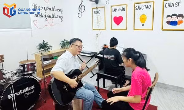 Em Trần Thị Oanh được nhạc sĩ Nguyễn Thiện Minh hướng dẫn cảm thụ âm nhạc trong buổi học đầu tiên của lớp âm nhạc dành cho trẻ rối loạn phát triển tại Trung tâm Hỗ trợ phát triển giáo dục hòa nhập Hướng Dương.