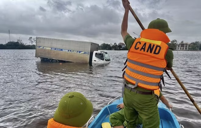 Lực lượng Công an xã Mỹ Thủy tiếp cận chiếc xe ôtô bị chết máy vì ngập nước lũ. Ảnh: Công an xã Mỹ Thủy