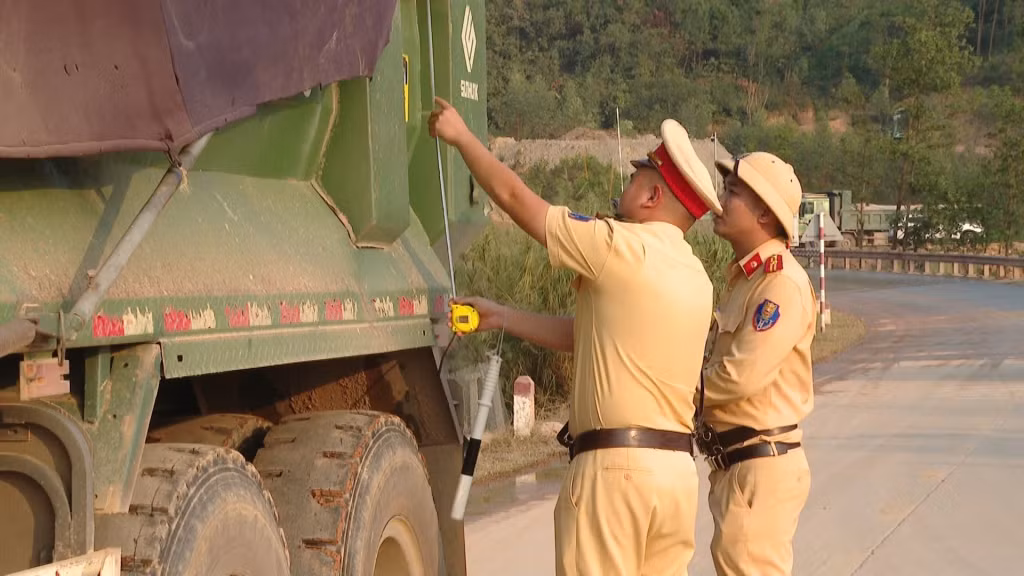Lực lượng CSGT - TT Công an TP Đông Triều đo kiểm tra chiều cao thành thùng phương tiện vận chuyển vật liệu trên địa bàn.