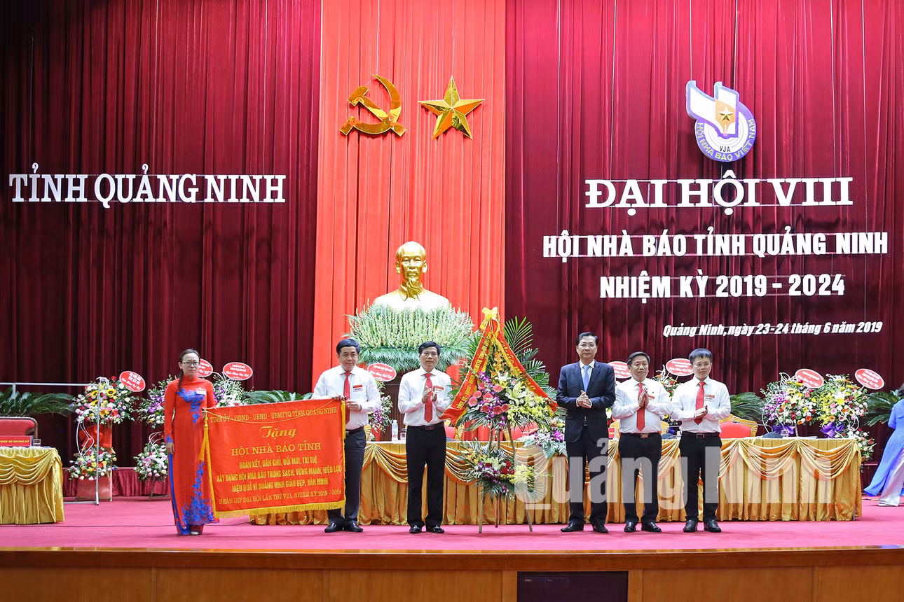Đồng chí Nguyễn Văn Đọc, Bí thư Tỉnh ủy, Chủ tịch HĐND tỉnh, trao bức trướng mang dòng chữ: “Đoàn kết, dân chủ, đổi mới, trí tuệ, xây dựng Hội Nhà báo trong sạch, vững mạnh, hiệu lực, hiệu quả vì Quảng Ninh giàu đẹp, văn minh” cho Hội Nhà báo tỉnh (6-2019). Ảnh: Hùng Sơn
