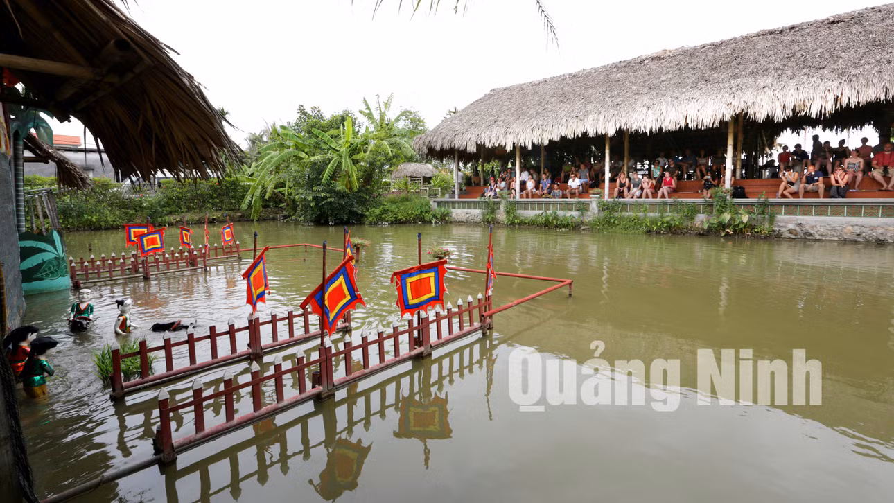 Du khách xem biểu diễn múa rối nước khi đến tham quan làng quê Yên Đức (7-2015). Ảnh: Khánh Giang