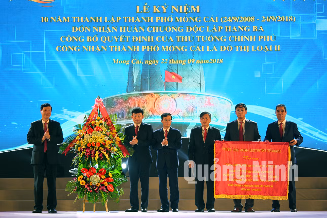 Phó Bí thư Tỉnh ủy, Chủ tịch UBND tỉnh Nguyễn Đức Long trao bức trướng của Tỉnh ủy - HĐND - UBND - Uỷ ban MTTQ tỉnh cho lãnh đạo TP Móng Cái (22-9-2018). Ảnh: Hùng Sơn