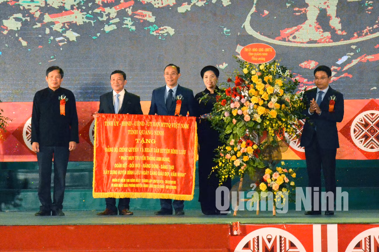 Chủ tịch UBND tỉnh Nguyễn Văn Thắng trao bức trướng với nội dung: “Phát huy truyền thống anh hùng, đoàn kết – đổi mới – năng động – sáng tạo, xây dựng huyện Bình Liêu ngày càng giàu đẹp, văn minh” cho huyện (12-2019). Ảnh: Mạnh Trường