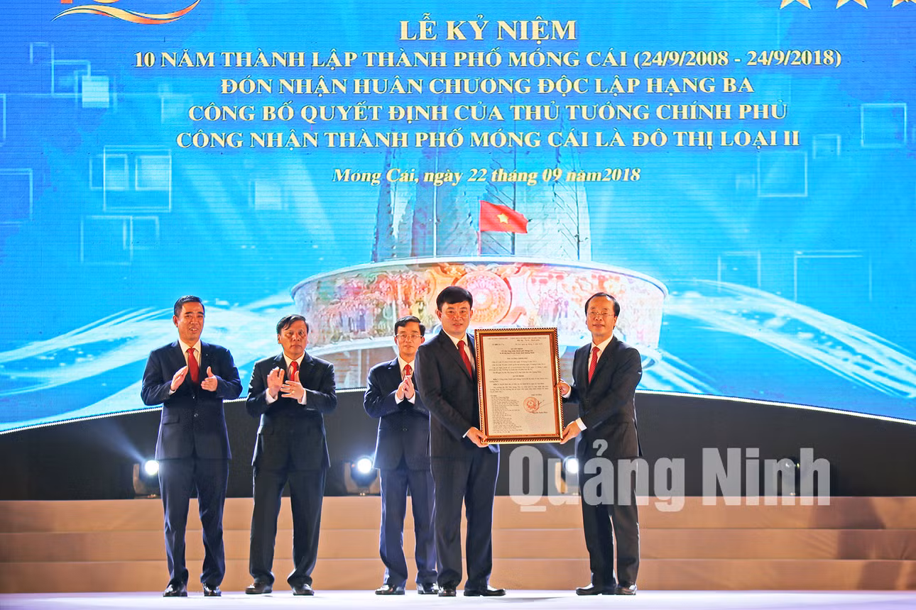 Đồng chí Phạm Hồng Hà, Ủy viên TƯ Đảng, Bộ trưởng Bộ Xây dựng, trao Quyết định của Thủ tướng Chính phủ công nhận TP Móng Cái là đô thị loại II trực thuộc tỉnh Quảng Ninh (22-9-2018). Ảnh: Hùng Sơn