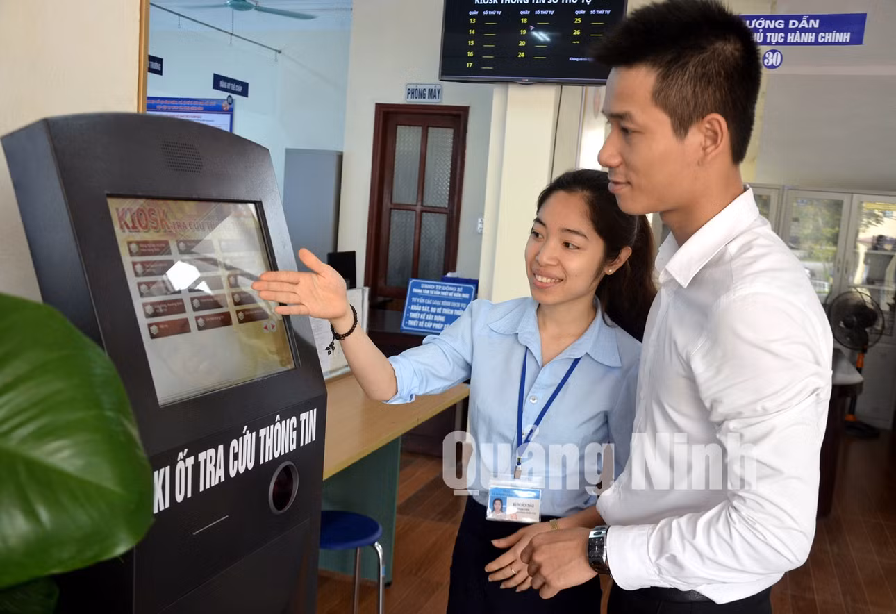Cán bộ Trung tâm Hành chính công thành phố hướng dẫn doanh nghiệp tra cứu thông tin. Ảnh: Hoàng Nga