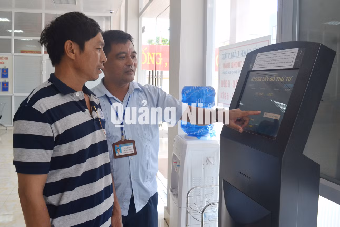 Cán bộ hướng dẫn người dân làm thủ tục tại Trung tâm HCC. Ảnh: Nguyễn Hoa