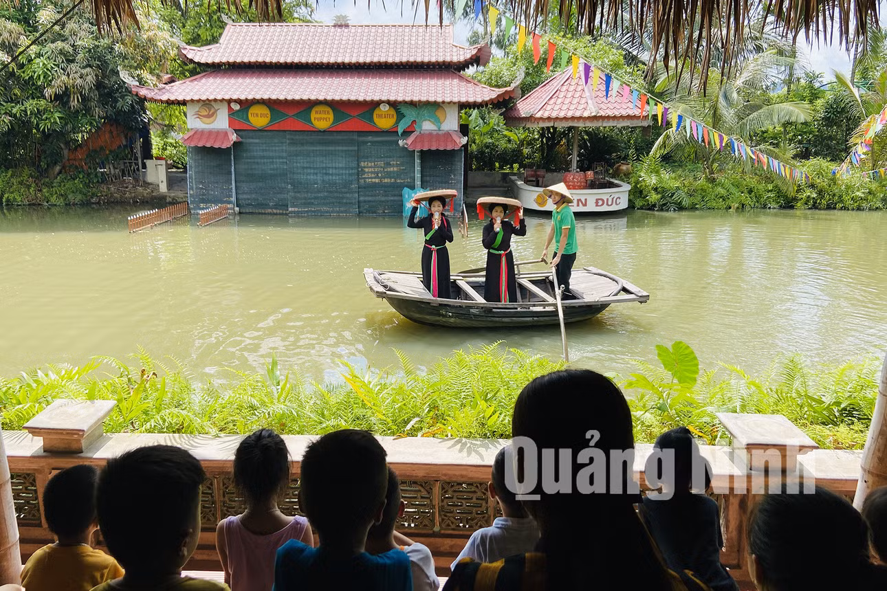 Du khách nghe hát quan họ, xem biểu diễn múa rối nước khi đến tham quan làng quê Yên Đức (6-2020). Ảnh: Hoàng Nga
