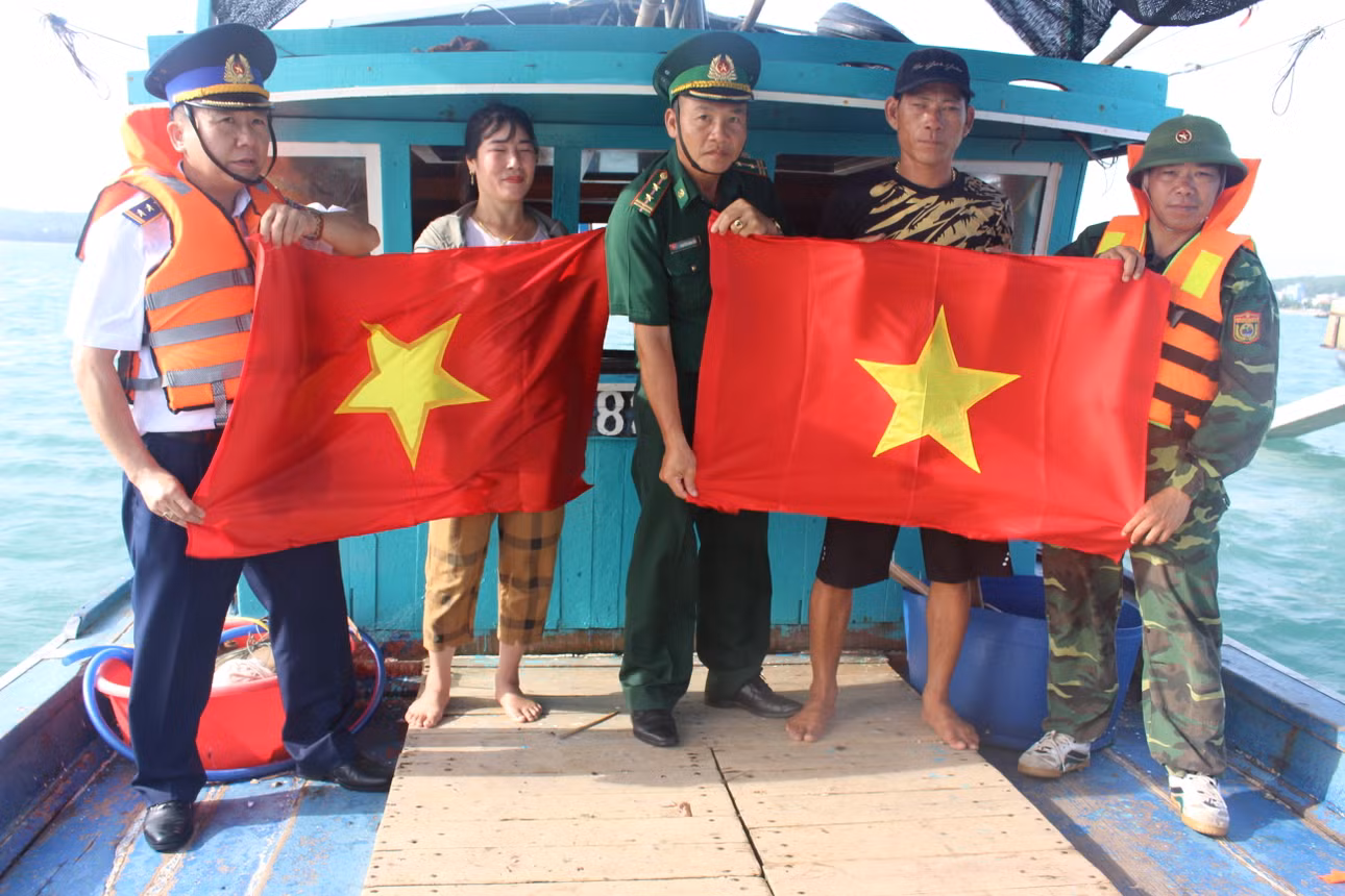 Chiến sĩ Đồn biên phòng Cô Tô tặng cờ Tổ quốc cho ngư dân bám biển.