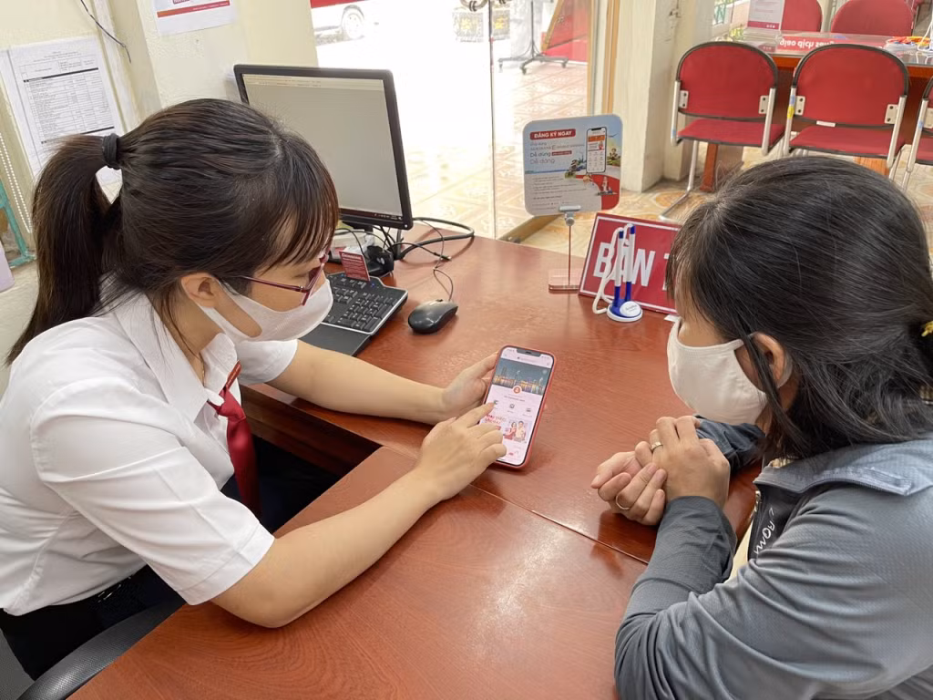 Cán bộ Agribank chi nhánh Tây Quảng Ninh hướng dẫn người dân sử dụng dịch vụ E-Mobile banking.