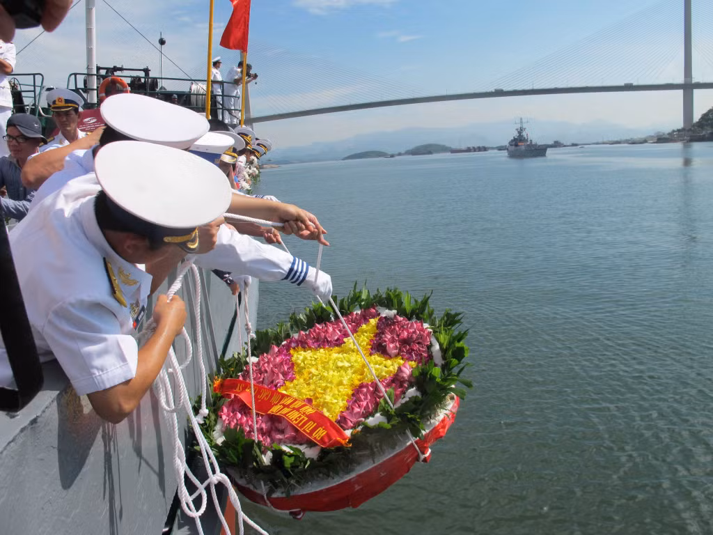 Bộ đội hải quân thả hoa xuống dòng sông Cửa Lục nơi nhiều đồng đội của họ đã hy sinh. Ảnh: Phạm Học.