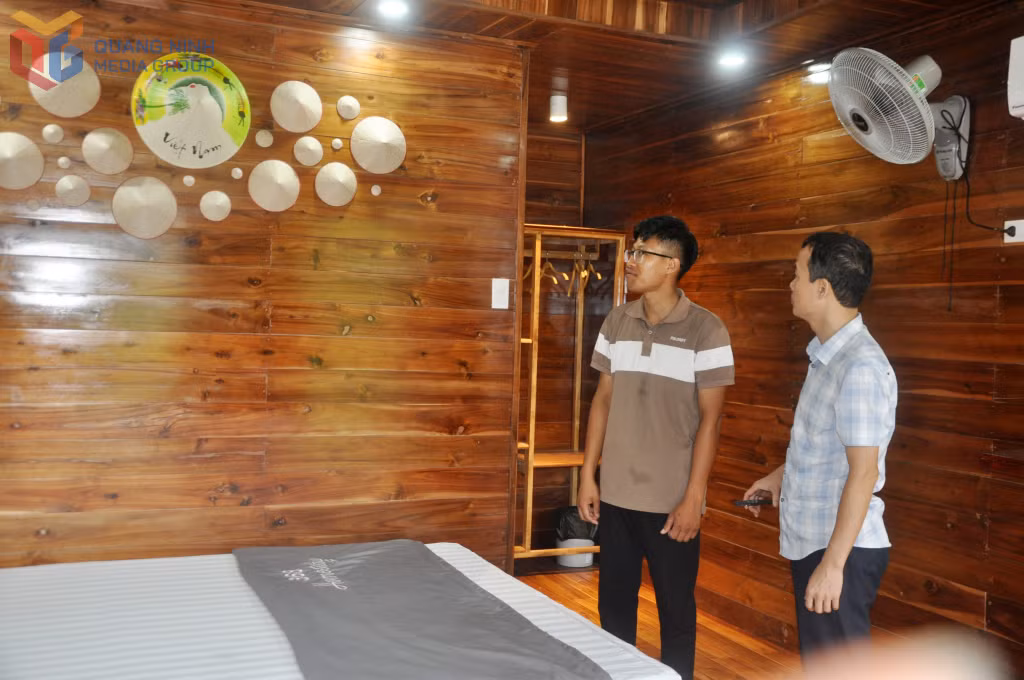 Anh Bùi Đức Khánh (trái) chia sẻ về việc đầu tư nội thất, trang trí phòng trong các căn nhà gỗ.