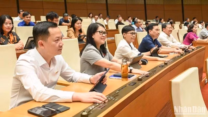 Các đại biểu Quốc hội biểu quyết thông qua Nghị quyết của Quốc hội về thí điểm về một số cơ chế, chính sách đặc thù phát triển nhà ở xã hội. (Ảnh: BÙI GIANG)