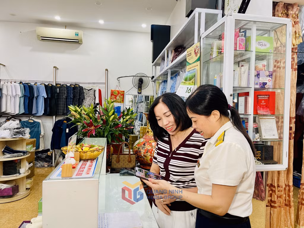 Cán bộ Đội thuế TP Đông Triều hướng dẫn các hộ kinh doanh sử dụng hoá đơn điện tử khởi tạo từ máy tính tiền.