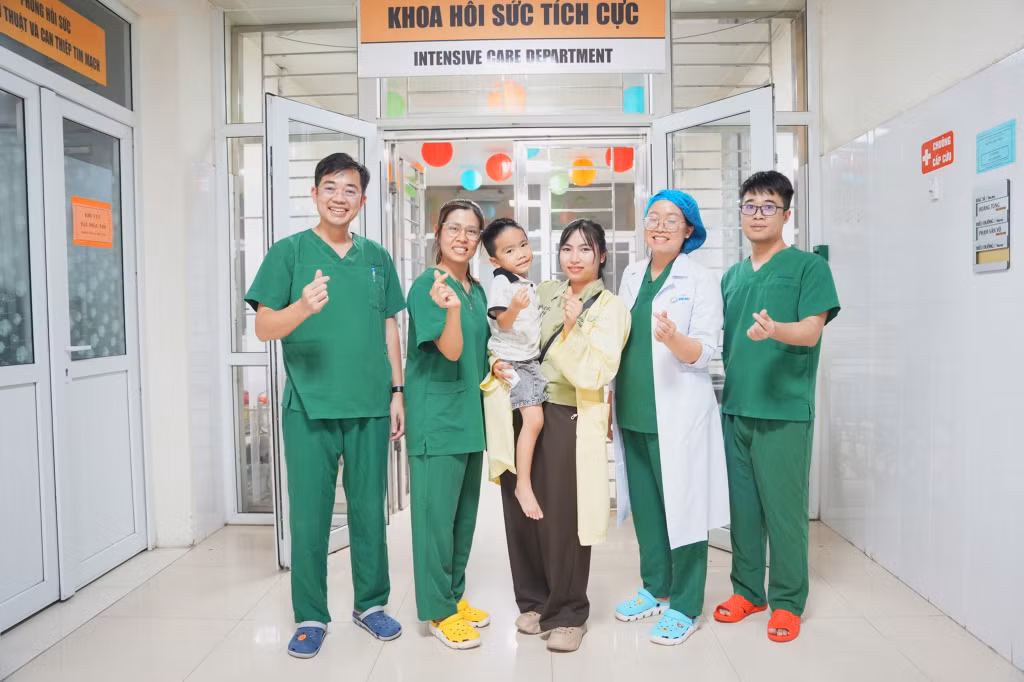 Các y, bác sĩ Bệnh viện Sản Nhi Quảng Ninh chúc mừng bệnh nhi mắc tay chân miệng khỏi bệnh và xuất viện.