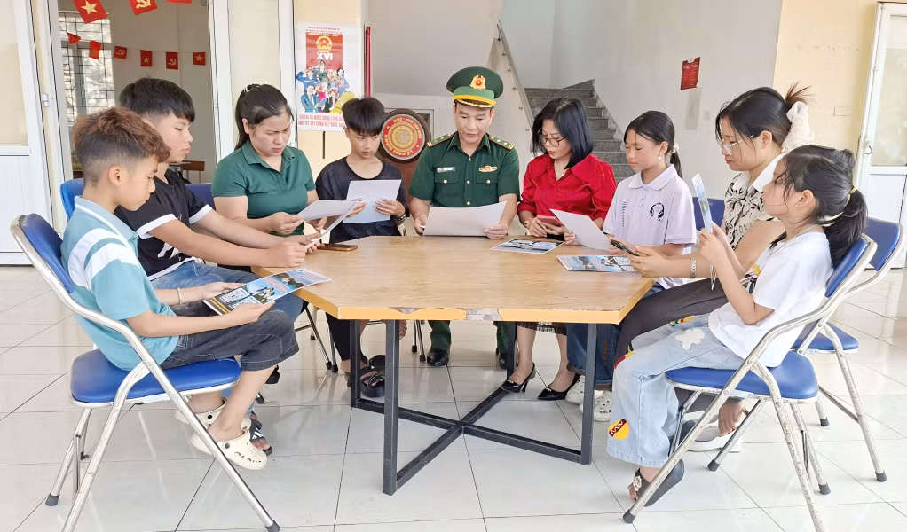 Cán bộ Đồn Biên phòng Đảo Trần hướng dẫn giáo viên, học sinh điểm trường thôn Trần cách sử dụng mã QR.