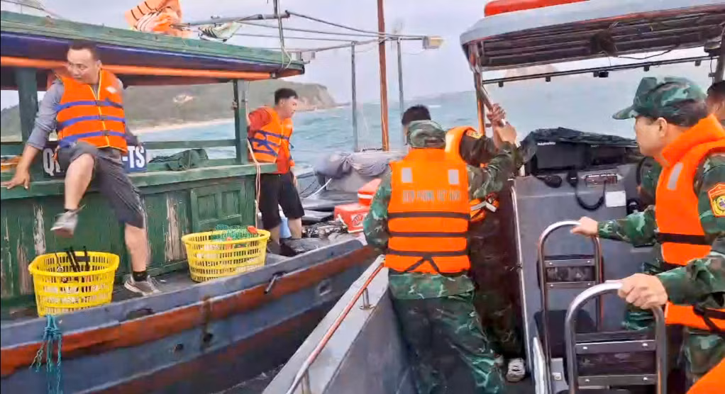 CBCS Đồn Biên phòng Thanh Lân đưa các ngư dân trên tàu gặp nạn lên xuồng cứu hộ. (Ảnh do đơn vị cung cấp).