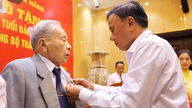 Đồng chí Trần Cẩm Tú, Ủy viên Bộ Chính trị, Thường trực Ban Bí thư trao Huy hiệu 80 năm tuổi Đảng cho đảng viên lão thành Trần Thanh Dân.