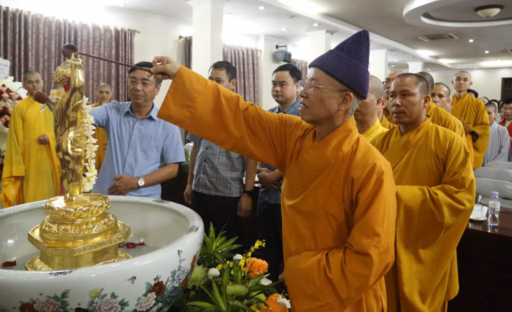Đại biểu và tăng ni phật tử thực hiện nghi thức tắm Phật.