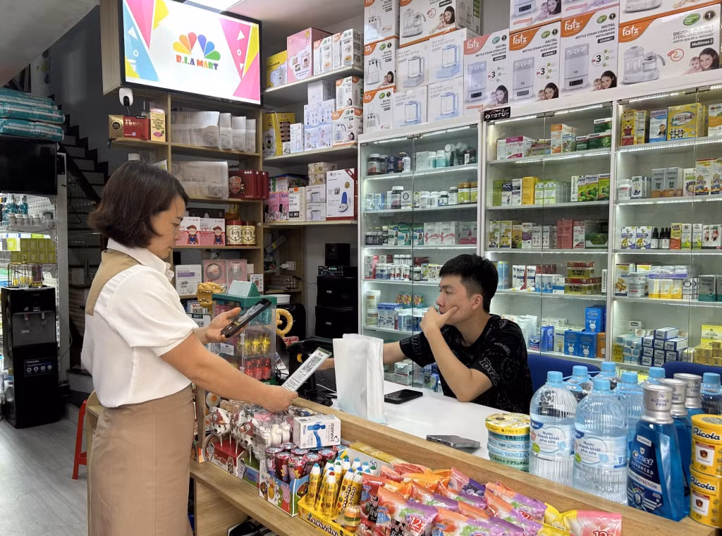 Khách hàng thanh toán bằng hình thức quét mã QR tại Chợ Trung tâm Tiên Yên (huyện Tiên Yên).)