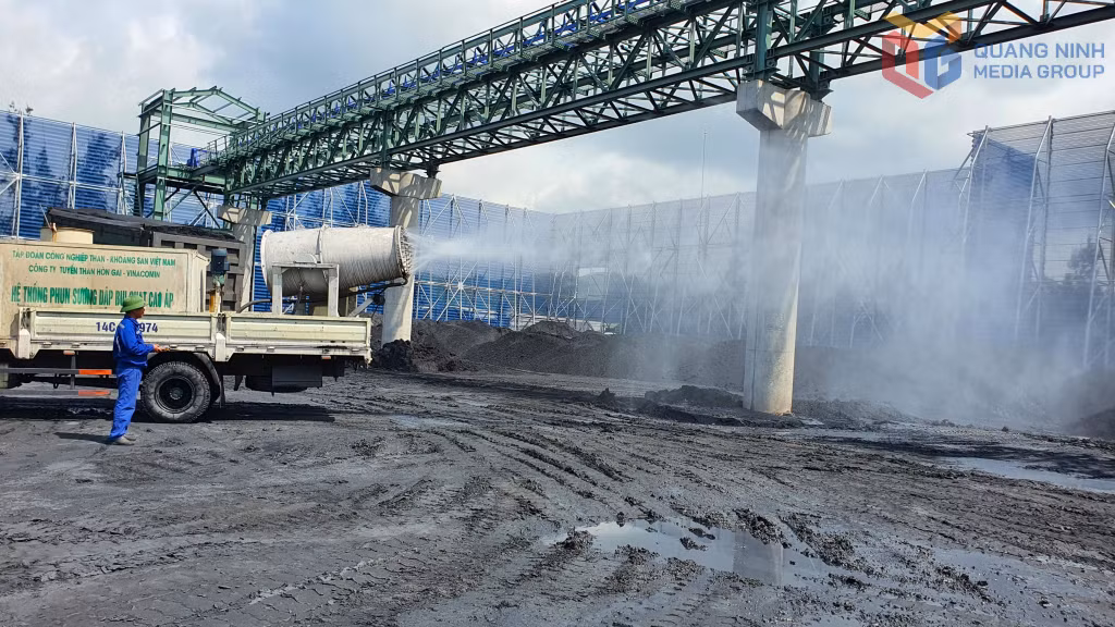 Công nhân vận hành xe phun sương dập bụi tại khu vực kho than.
