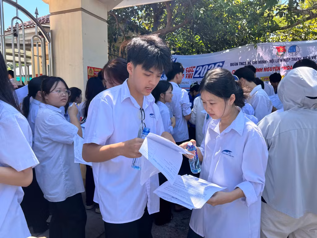 Các sĩ tử trao đổi lại bài làm của mình sau giờ thi. Ảnh: Lưu Linh.
