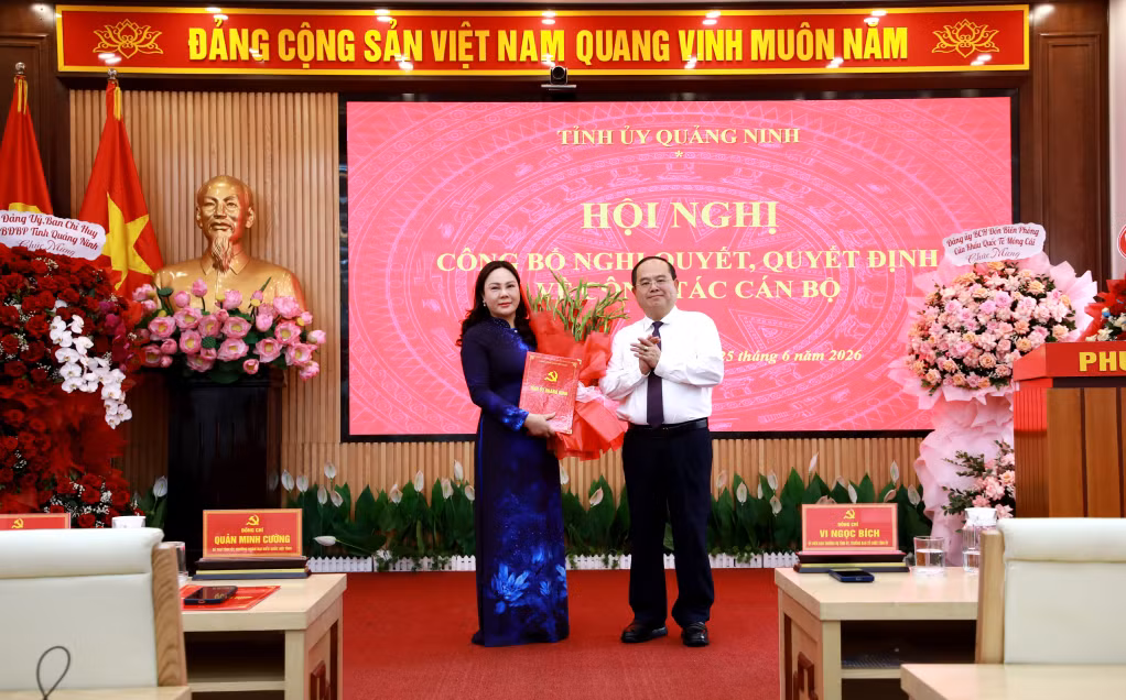 Đồng chí Quản Minh Cường, Ủy viên BCH Trung ương Đảng, Bí thư Tỉnh ủy, Trưởng Đoàn ĐBQH tỉnh, trao quyết định, tặng hoa chúc mừng đồng chí Nguyễn Thị Hiền, Bí thư Đảng ủy phường Móng Cái 1.