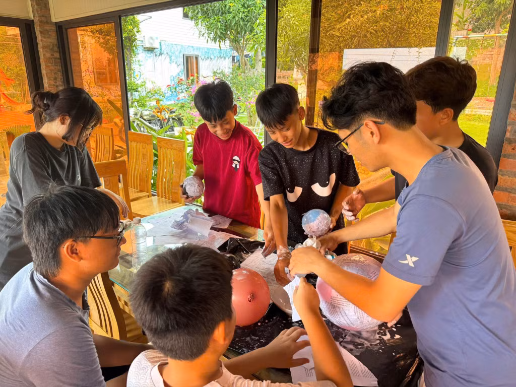 Các tình nguyện viên hướng dẫn các em học sinh làm mô hình hành tinh trong dải Ngân hà.