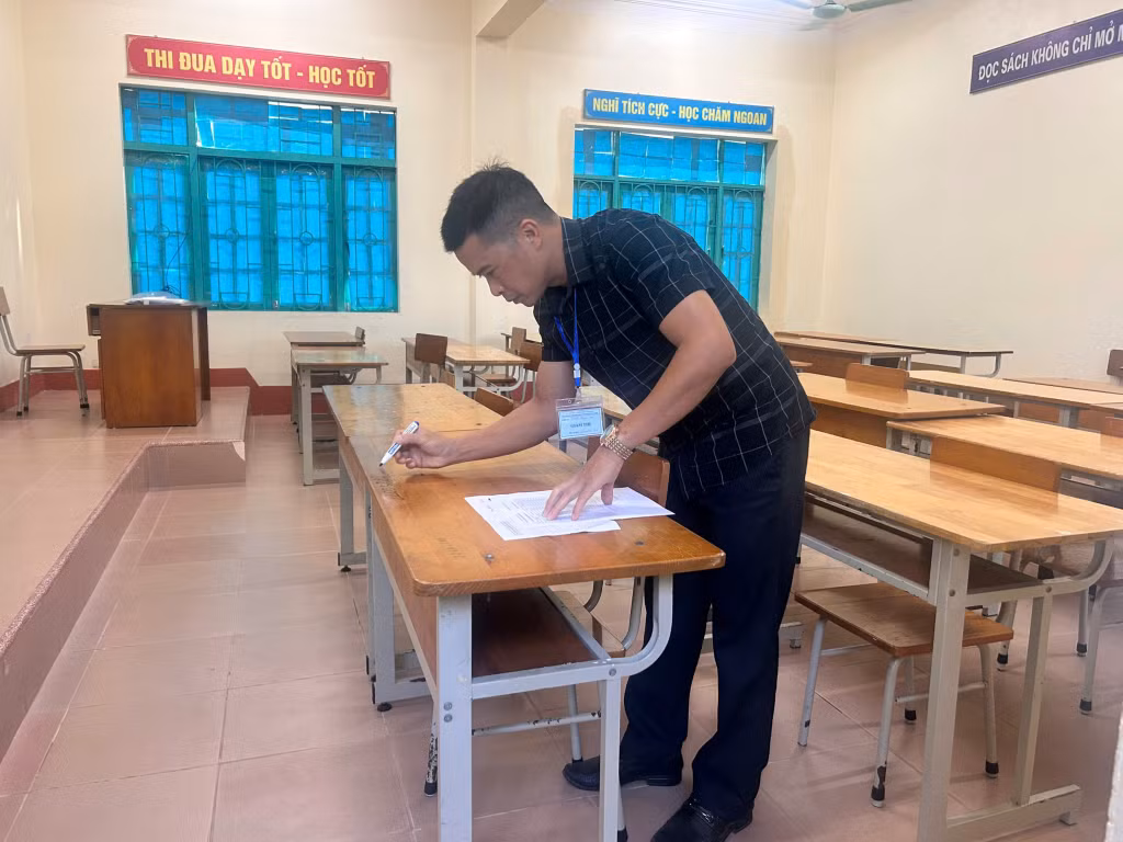 Cán bộ làm thi tại Điểm thi Trường THPT Nguyễn Trãi (xã Tiên Yên) điền thông tin số báo danh, sắp xếp chỗ ngồi thi cho thí sinh. Ảnh: Lưu Linh.
