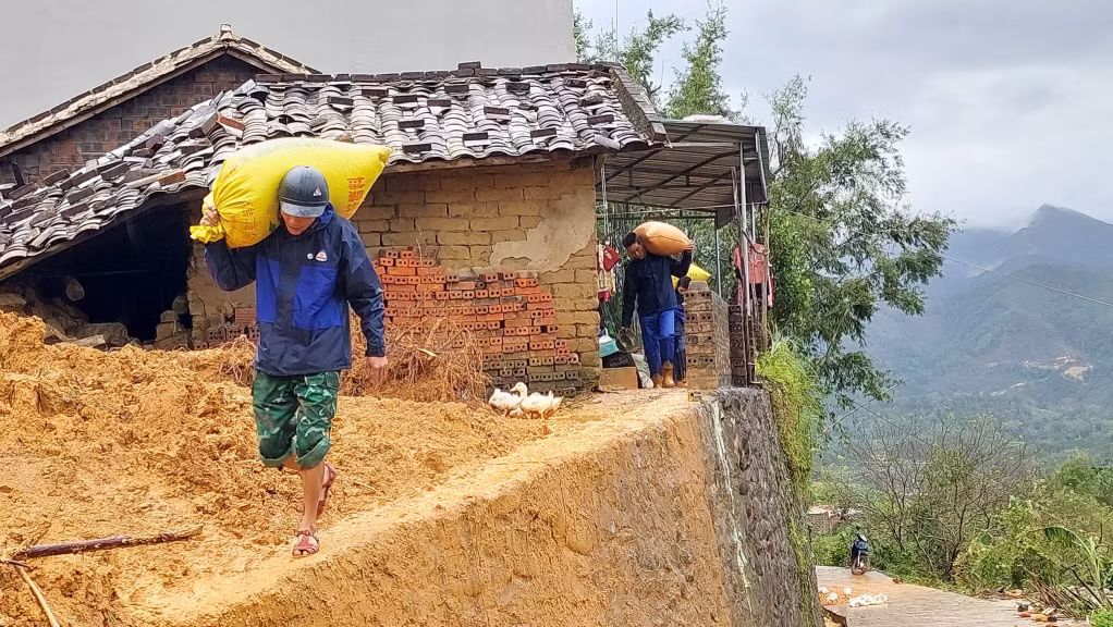 Cán bộ, chiến sĩ LLVT huyện hỗ trợ nhân dân thôn Cao Thắng (xã Lục Hồn) di tản ra khỏi khu vực có nguy sạt lở. Ảnh: La Lành (CTV)