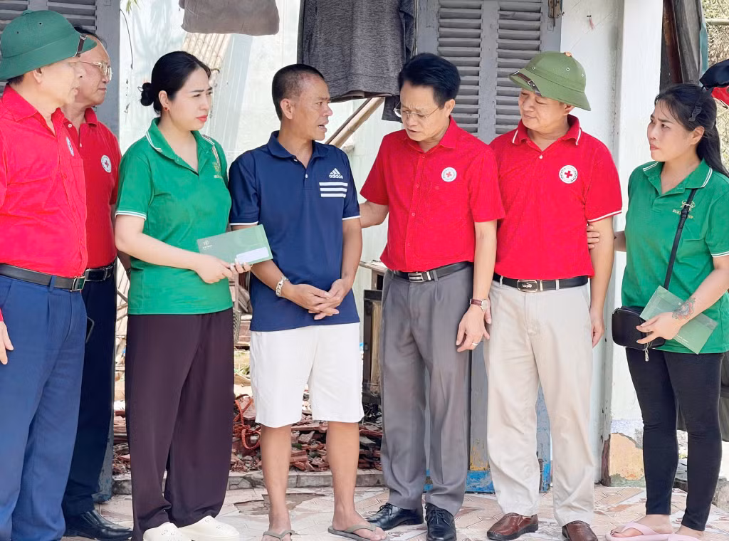 Chủ tịch Hội Chữ thập đỏ TP Hà Nội Lê Ngọc Triệu (thứ 3 phải vào) động viên thăm hỏi hộ gia đình ông Nguyễn Hữu Hội ở tổ 5, khu 1, phường Hà Tu (TP Hạ Long).