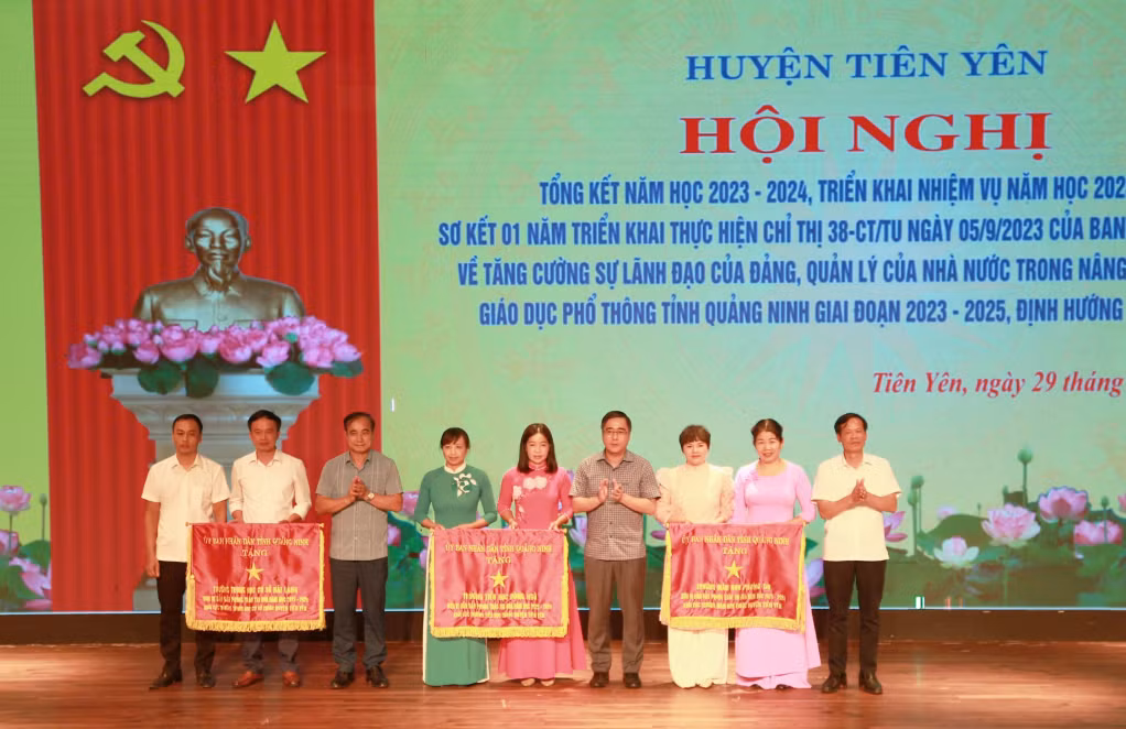 Lãnh đạo huyện Tiên Yên trao tặng cờ thi đua của UBND tỉnh cho 3 trường học dẫn đầu phong trào thi đua ngành Giáo dục huyện. Ảnh: Trần Hoàn (CTV)