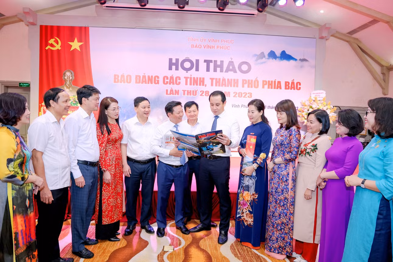 Đại biểu xem báo, trao đổi kinh nghiệm tại Hội thảo.