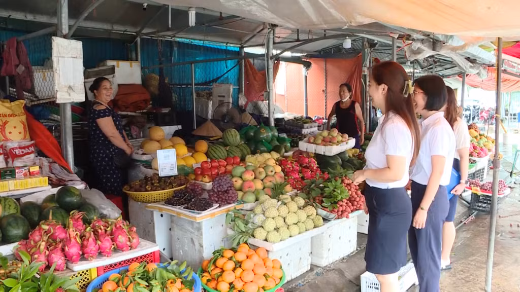 Nhân viên ngân hàng hướng dẫn, hỗ trợ các tiểu thương tại chợ Trung tâm huyện Hải Hà sử dụng dịch vụ internet banking.