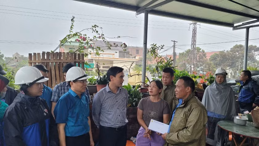 Chủ tịch Công đoàn TKV Lê Thanh Xuân (đứng giữa) đến thăm và động viên gia đình công nhân Trần Thành Vân (Công ty Tuyển than Cửa Ông) bị thiệt hại do bão số 3.