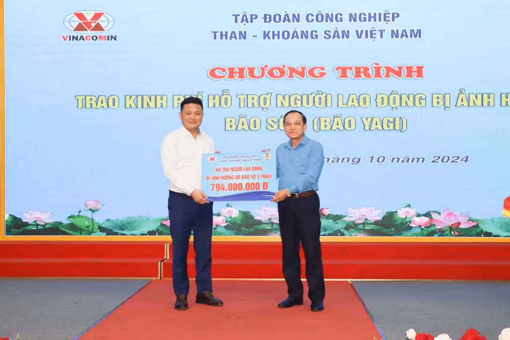 Thay mặt lãnh đạo Tập đoàn, Chủ tịch Công đoàn Công ty Than Hạ Long Đỗ Văn Hùng (bên phải) trao số tiền 794 triệu đồng hỗ trợ CNLĐ Công ty bị thiệt hại do bão số 3.