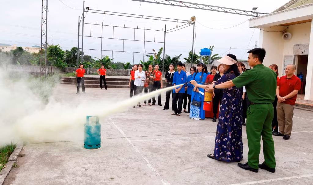 Công an TP Móng Cái hướng dẫn hội viên phụ nữ sử dụng bình chữa cháy.