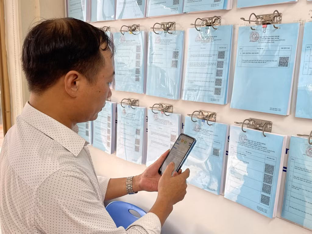 Người dân quét mã tra cứu các thủ tục hành chính tại bảng niêm yết.