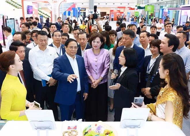 Thủ tướng Phạm Minh Chính tham quan trưng bày về ứng dụng Chuyển đổi Số trong lĩnh vực ngân hàng. (Ảnh: Dương Giang/TTXVN)