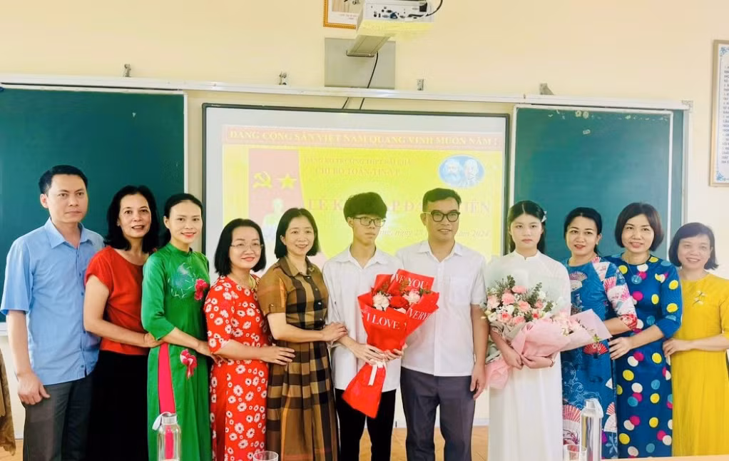 Lãnh đạo Đảng ủy và lãnh đạo trường THPT Bãi Cháy tặng hoa chúc mừng các đồng chí đảng viên mới. Ảnh do đơn vị cung cấp